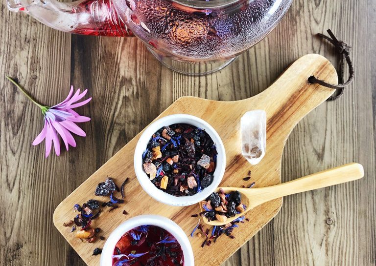 Blue Moon herbal tea in glass teapot with loose leaves in teacups
