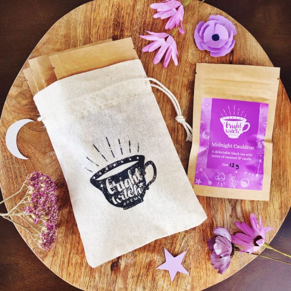 Bright Witch Favourite's Tea Bundle. Image shows a small cotton drawstring bag stamped with the Bright Witch teacup logo, with four tea taster sachets.