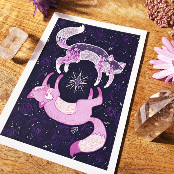 Image shows a printed art card featuring two ethereal foxes encircling a silver star