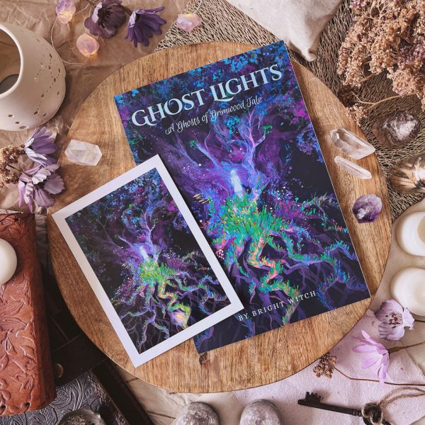 Photograph of Ghost Lights novelette and corresponding mini art print. Cover and mini print illustrations feature a ghostly girl standing at the base of a spectral tree. At her feet sprawls a vibrant garden of flowers.